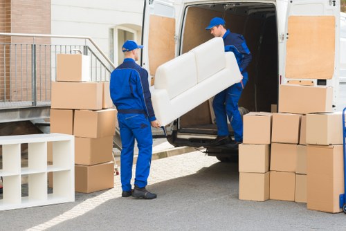 Professional movers loading furniture into a transport vehicle